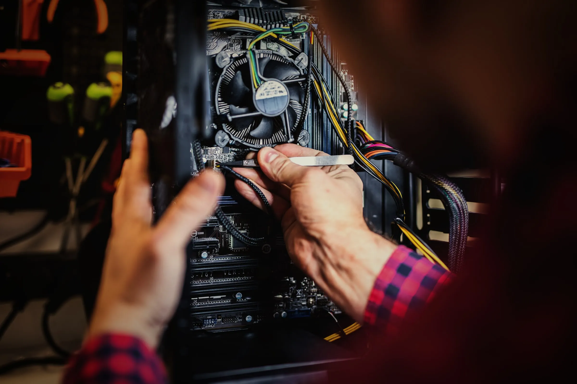Hände prüfen die Komponenten in einem geöffneten PC.