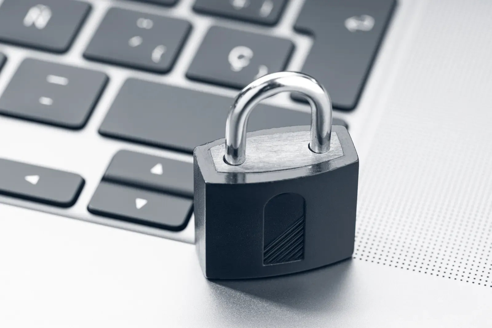 Vorhängeschloss auf einer Notebook-Tastatur, Sinnbild für IT-Sicherheit im Betrieb