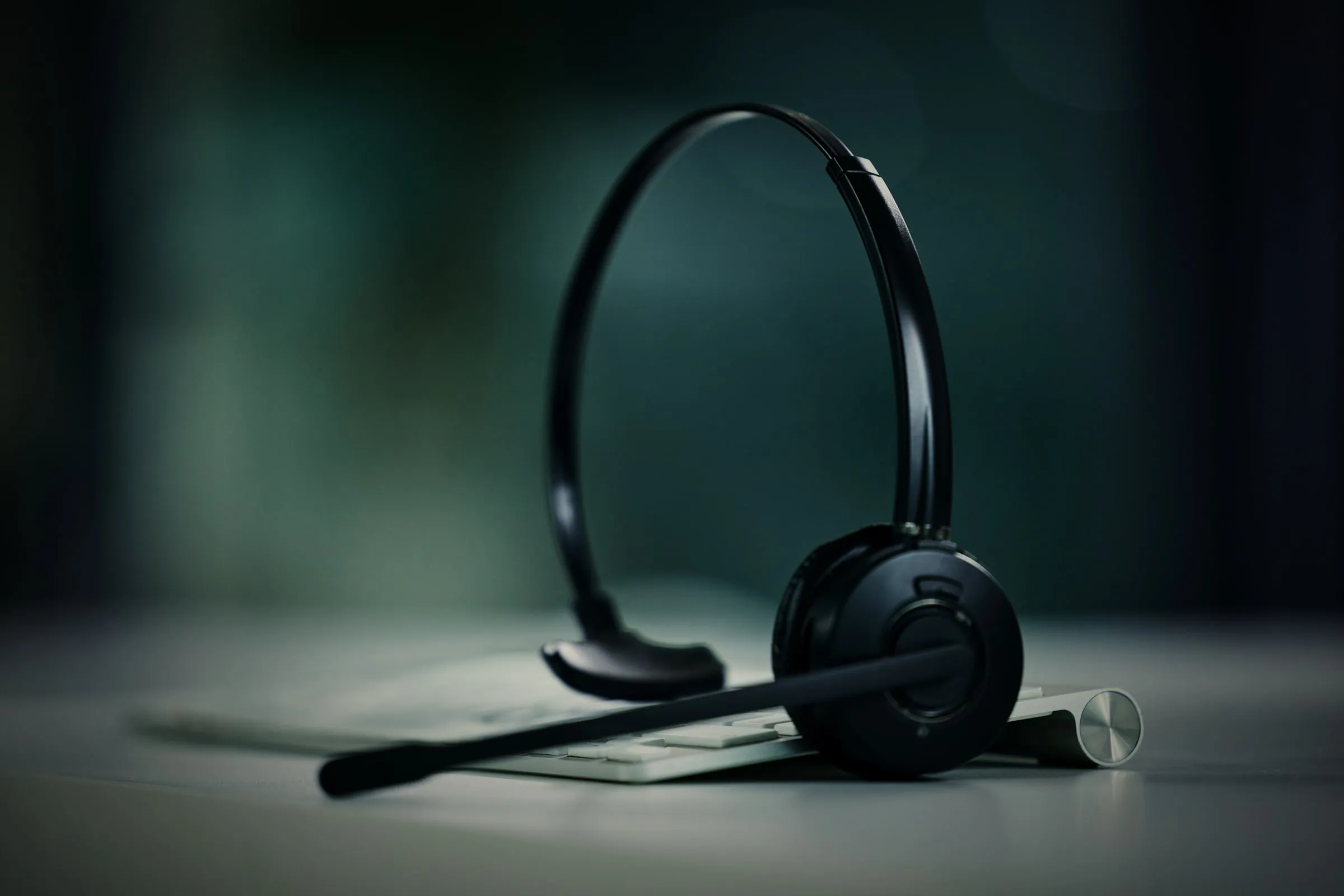 Headset auf der Tastatur am Arbeitsplatz, telefoniert wird direkt am Computer